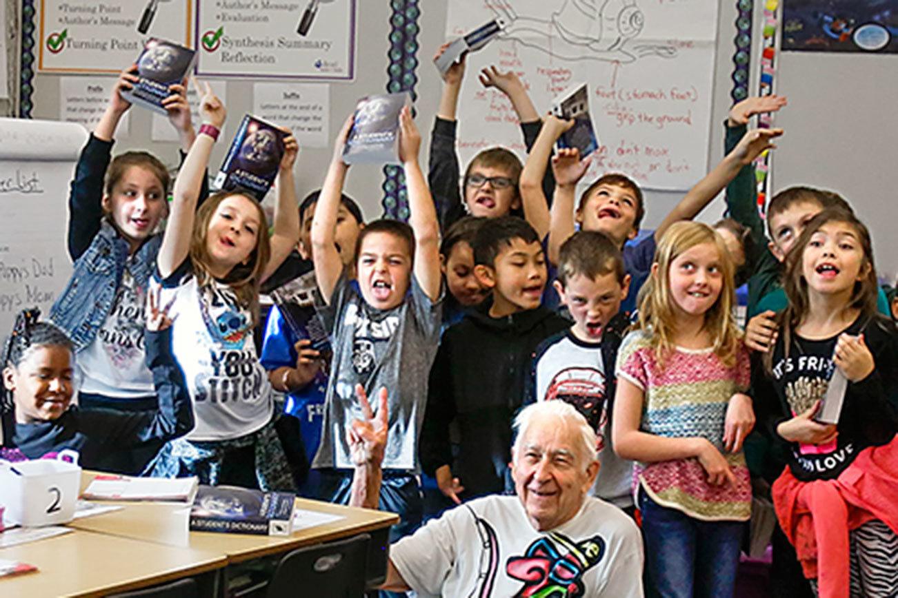 Kiwanis Club volunteers Jack Lapoint (center floor) and James Henry (right) pose with third-graders for teacher Christi Castro to photograph after giving the kids new dictionaries from the Kiwanis Club for the last time. (Dan Bates / The Herald)