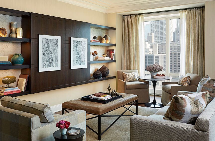 A narrow cabinet in a family room sports sliding panels that mask the TV for more formal occasions. Interesting artwork on the panels make sure they do double duty by anchoring pieces from the homeowner’s art collection. (Nathan Kirkman/Los Angeles Times)
