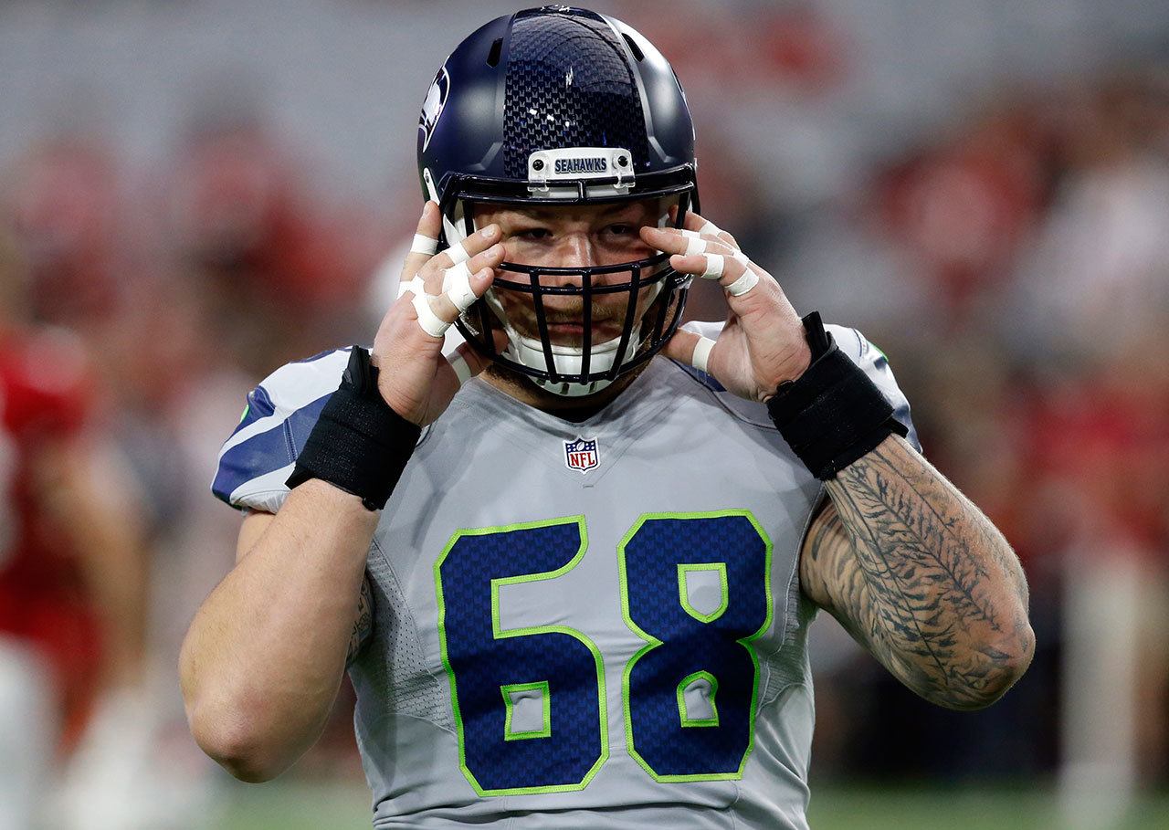 Seahawks center Justin Britt (68) puts on his helmet prior to a game against the Cardinals on Oct. 23 in Glendale, Ariz. (AP Photo/Ross D. Franklin)