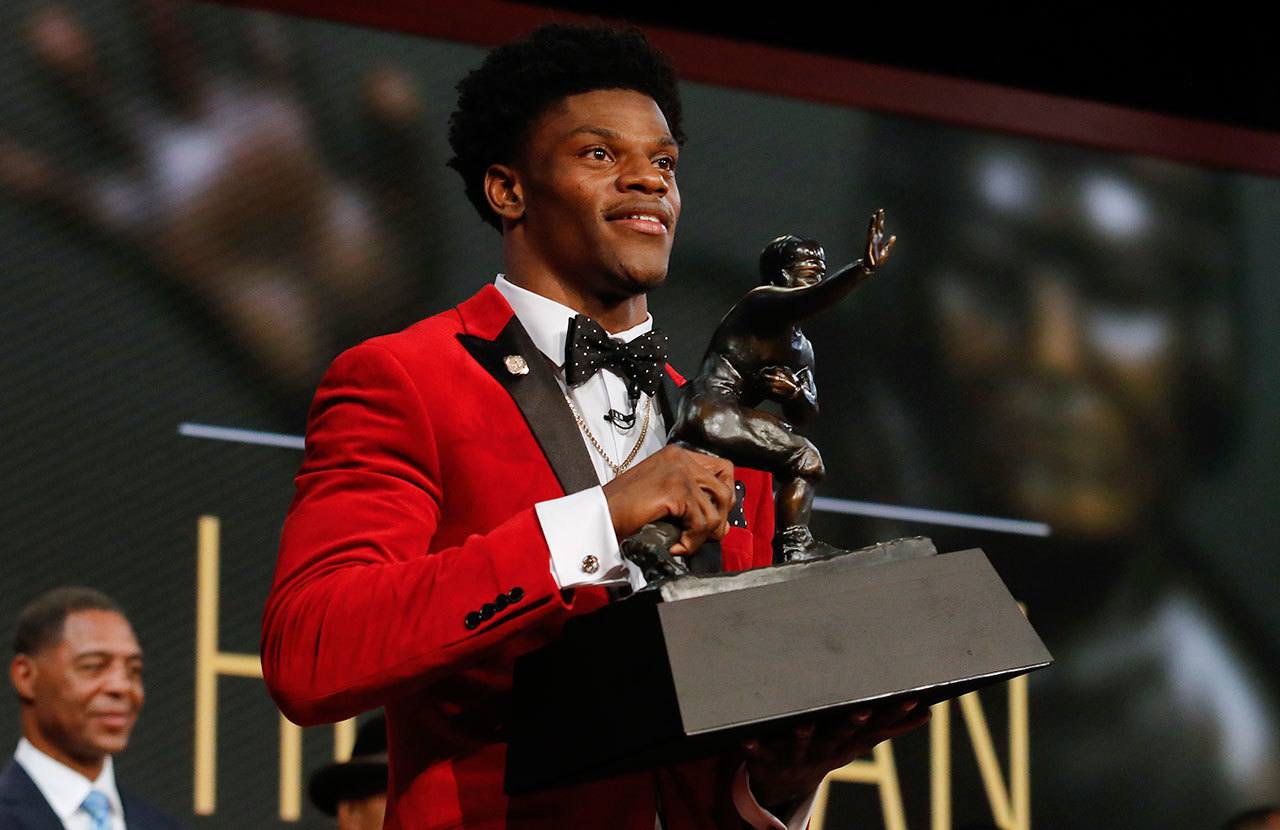 Louisville’s Lamar Jackson holds up the Heisman Trophy after winning the award Saturday in New York. (Todd Van Emst/Heisman Trophy Trust via AP)