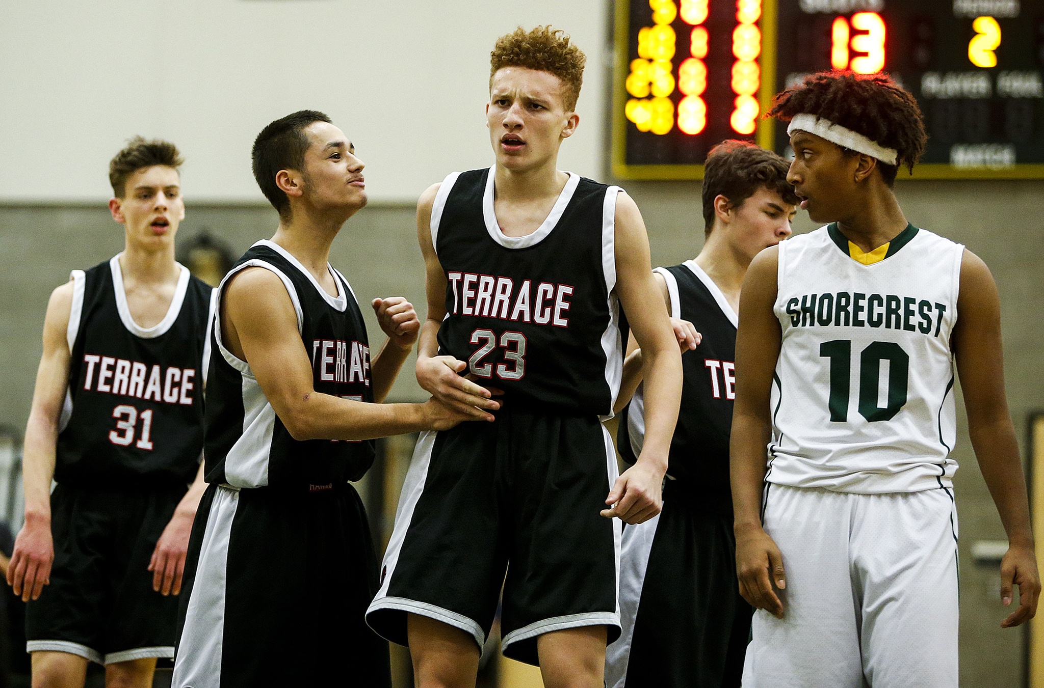 Mountlake Terrace’s Khyree Armstead (center) celebrates a basket with teammate Joey Gardner (center left) as Shorecrest’s Dagmawe Menelik looks on during a game on Tuesday at Shorecrest High School in Shoreline. (Ian Terry / The Herald)