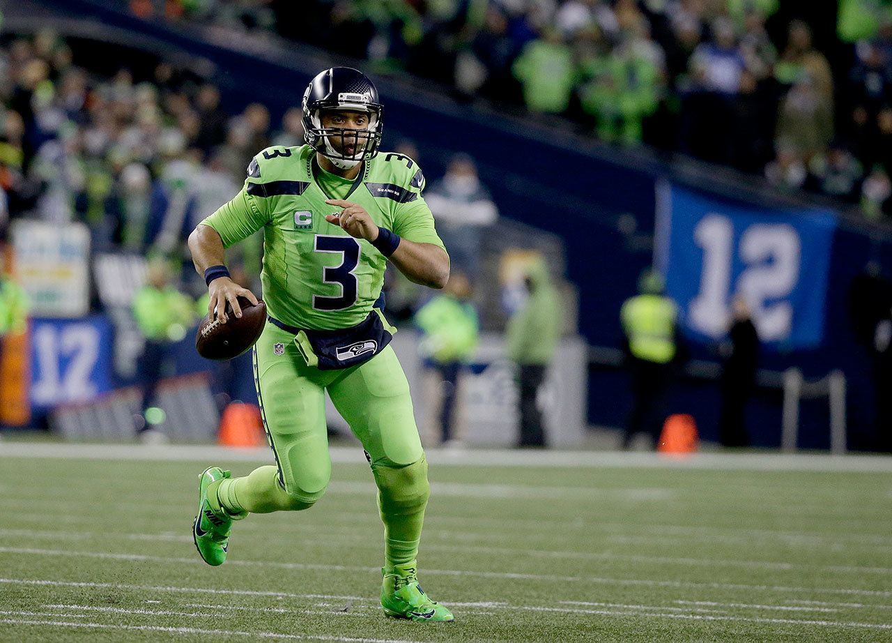 Seattle quarterback Russell Wilson scrambles during the Seahawks’ 24-3 win over the L.A. Rams on Thursday in Seattle. (AP Photo/Elaine Thompson)