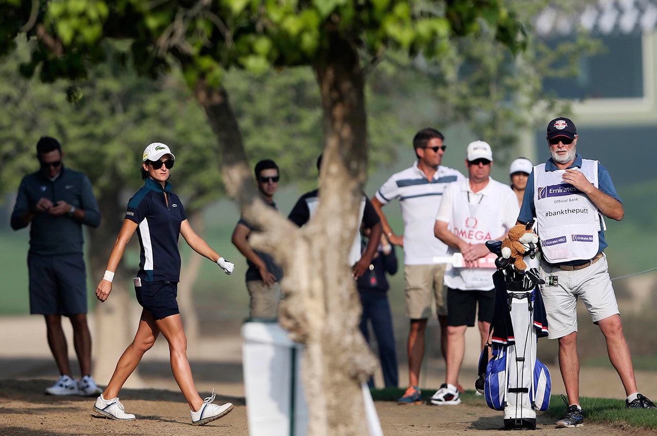 Anne-Lise Caudal of France studies her shot next to her caddie, Maximilian Zechmann (far right), on the 10th hole during the first round of Dubai Ladies Masters golf tournament Wednesday in Dubai, United Arab Emirates. Zechmann, 56, collapsed three holes later. (AP Photo/Kamran Jebreili)