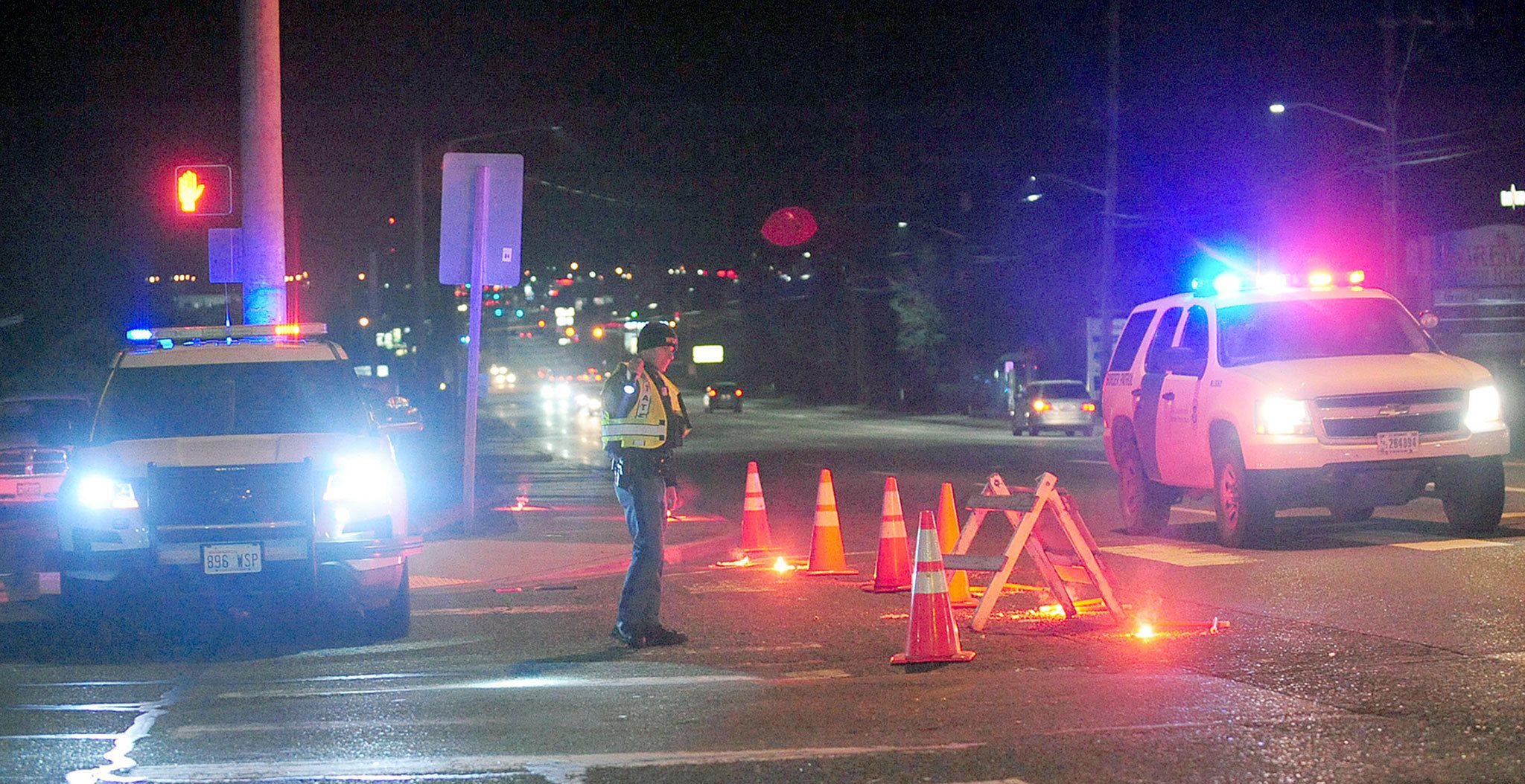 A Washington State Patrol trooper directs traffic around a roadblock near Skagit Valley College on Thursday after a Mount Vernon Police officer was shot and critically wounded. (Brandy Shreve/Skagit Valley Herald via AP)