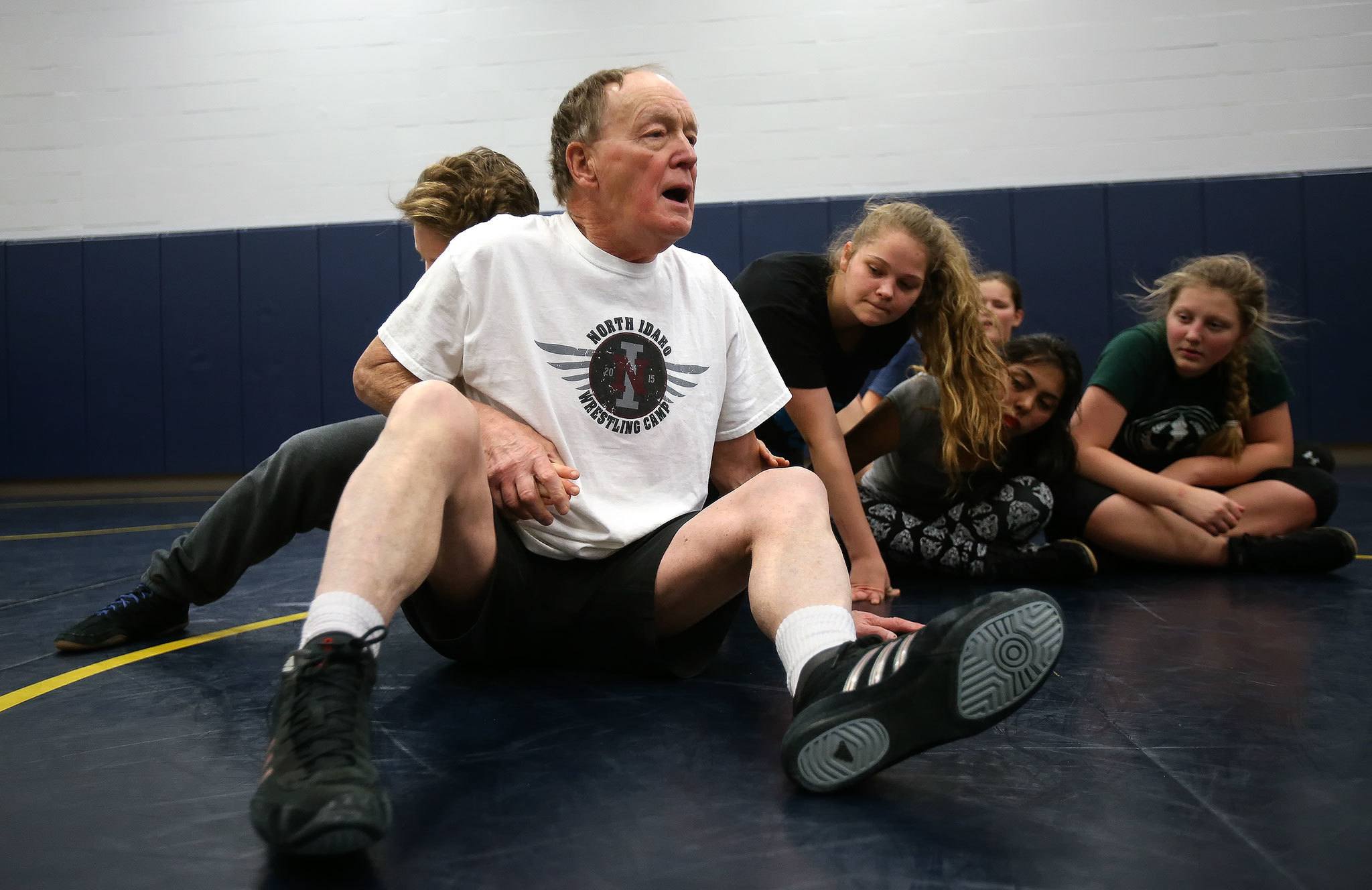 Rick Iversen demonstrates a maneuver as he coaches the Everett girls wrestling team during practice on Wednesday. (Andy Bronson/The Herald)