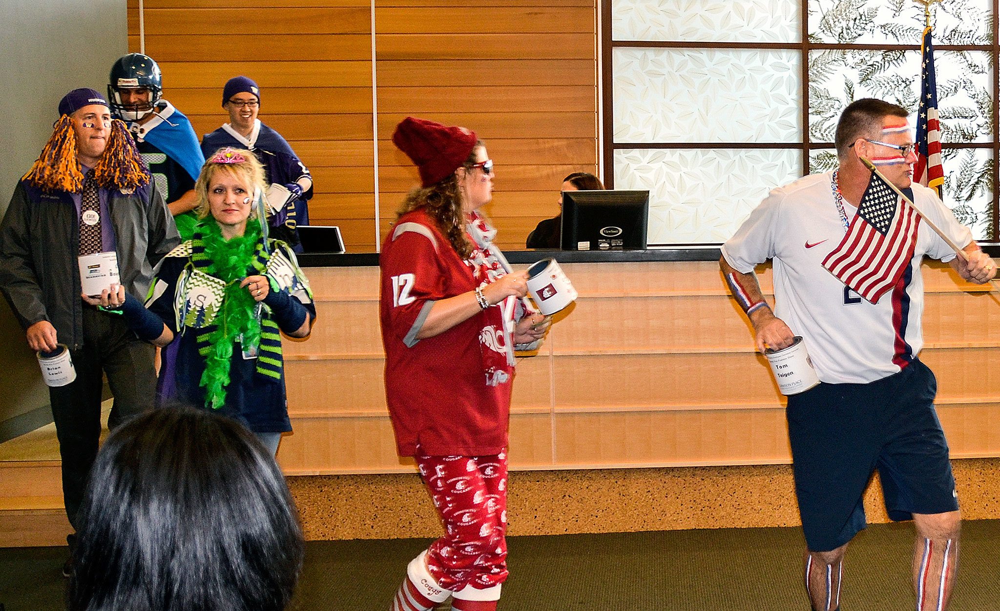Snohomish County employees show off their favorite sports-fan regalia in October during a fundraising fashion show at the county administration building. Last week, they donated $1,209 to the Everett Gospel Mission Women and Children’s Shelter. (Photo courtesy Snohomish County)