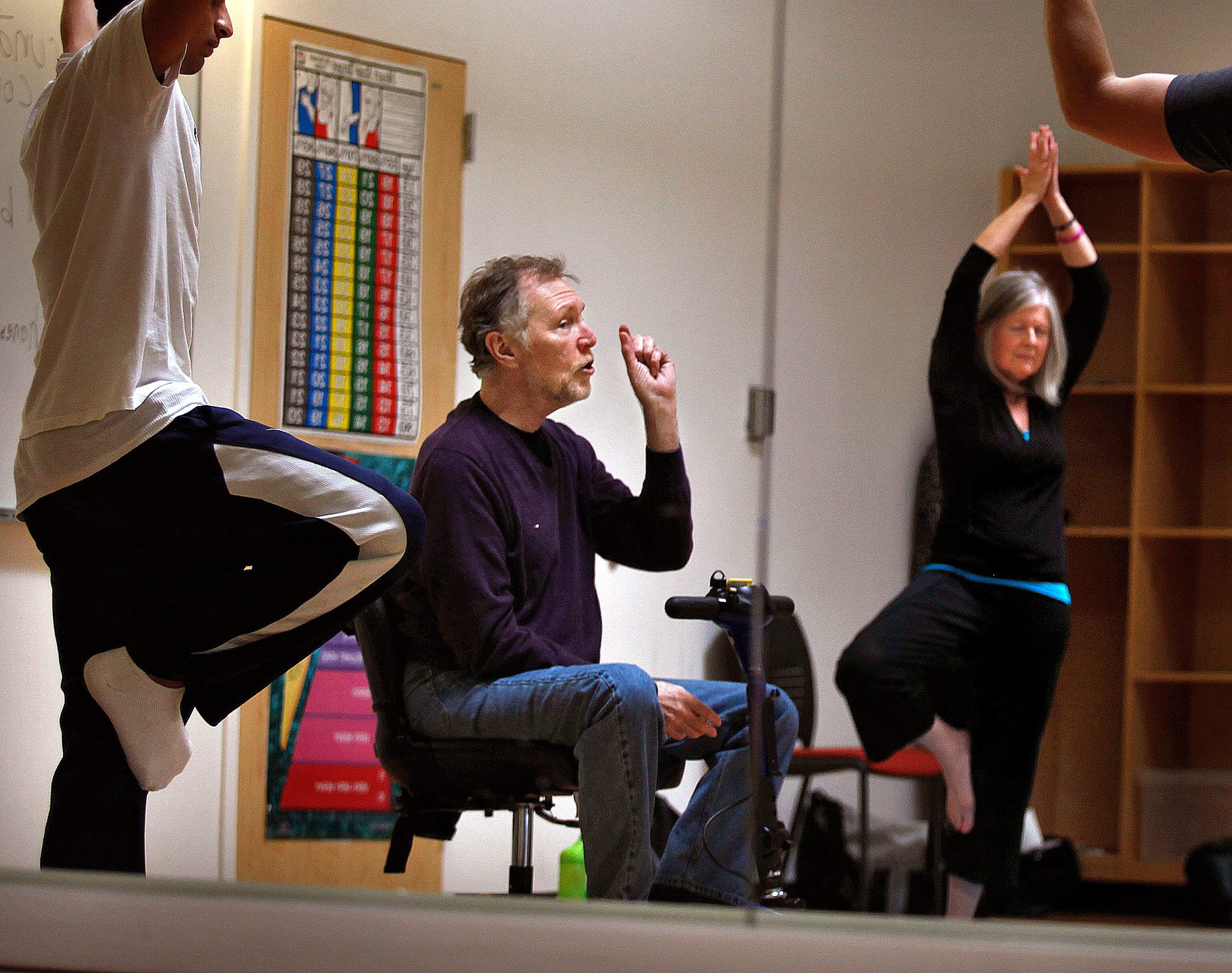 From a seat on an electric scooter, and with wife Diane Brooks nearby, Paul MacNaughton leads a yoga class at Everett Community College on April 25, 2013. MacNaughton died Dec. 16 following a long battle with bone cancer. (Dan Bates / The Herald)