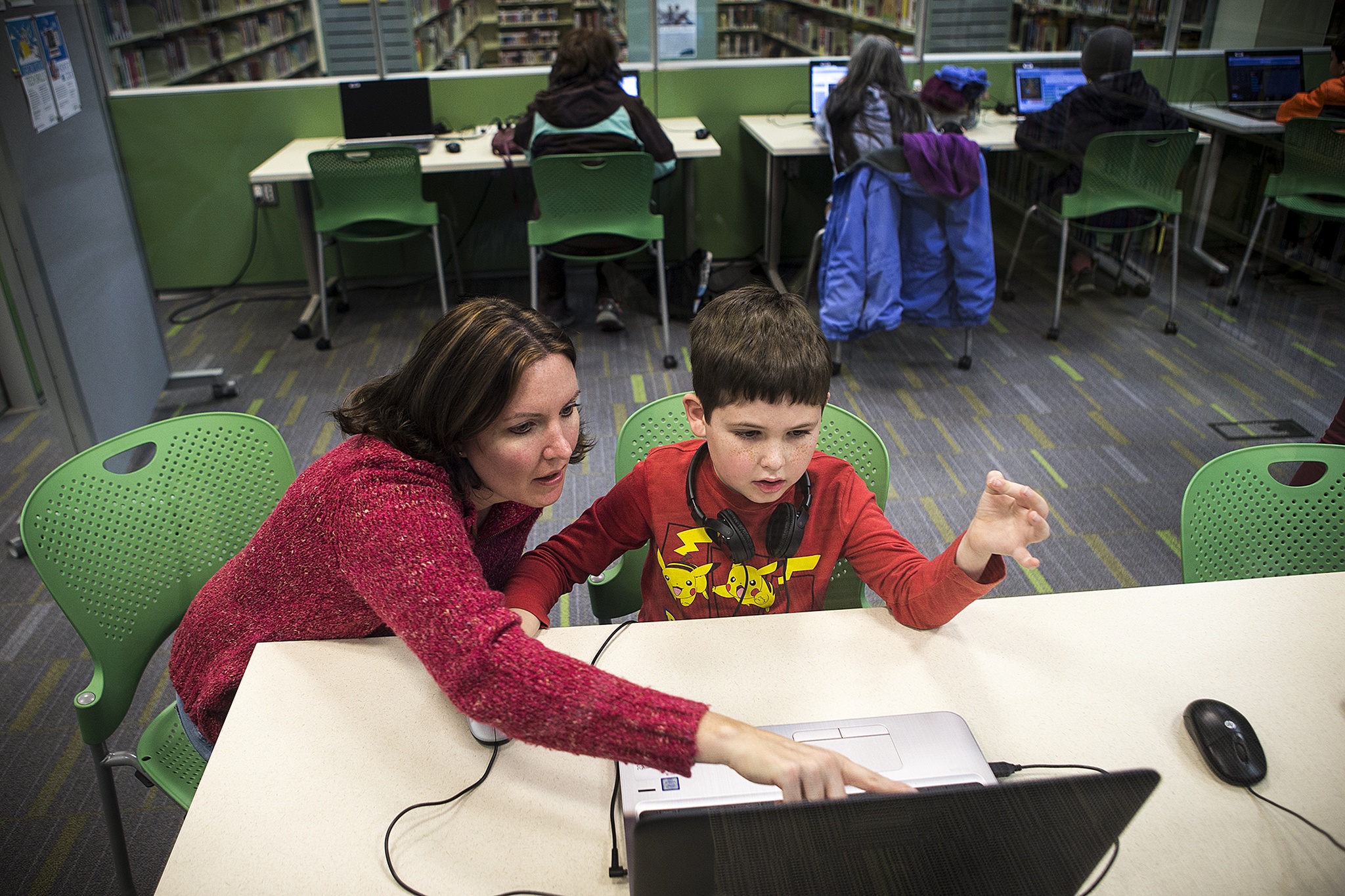 Alexander Reed, 7, of Everett, and his mom, Yvonne, work through a computer coding program together at the “Hour of Code” event at the Lynnwood Library on Saturday, Dec. 10. (Ian Terry / The Herald)