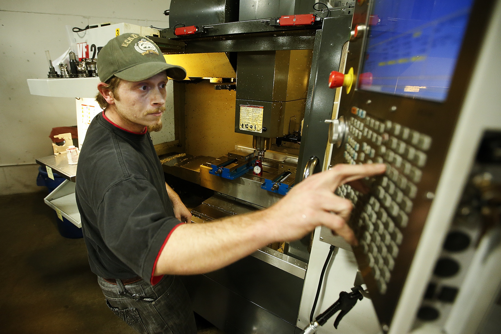 Machinist David Willis makes adjustments to a CNC machine at RB Enterprises in Mukilteo on Wednesday. (Ian Terry / The Herald)