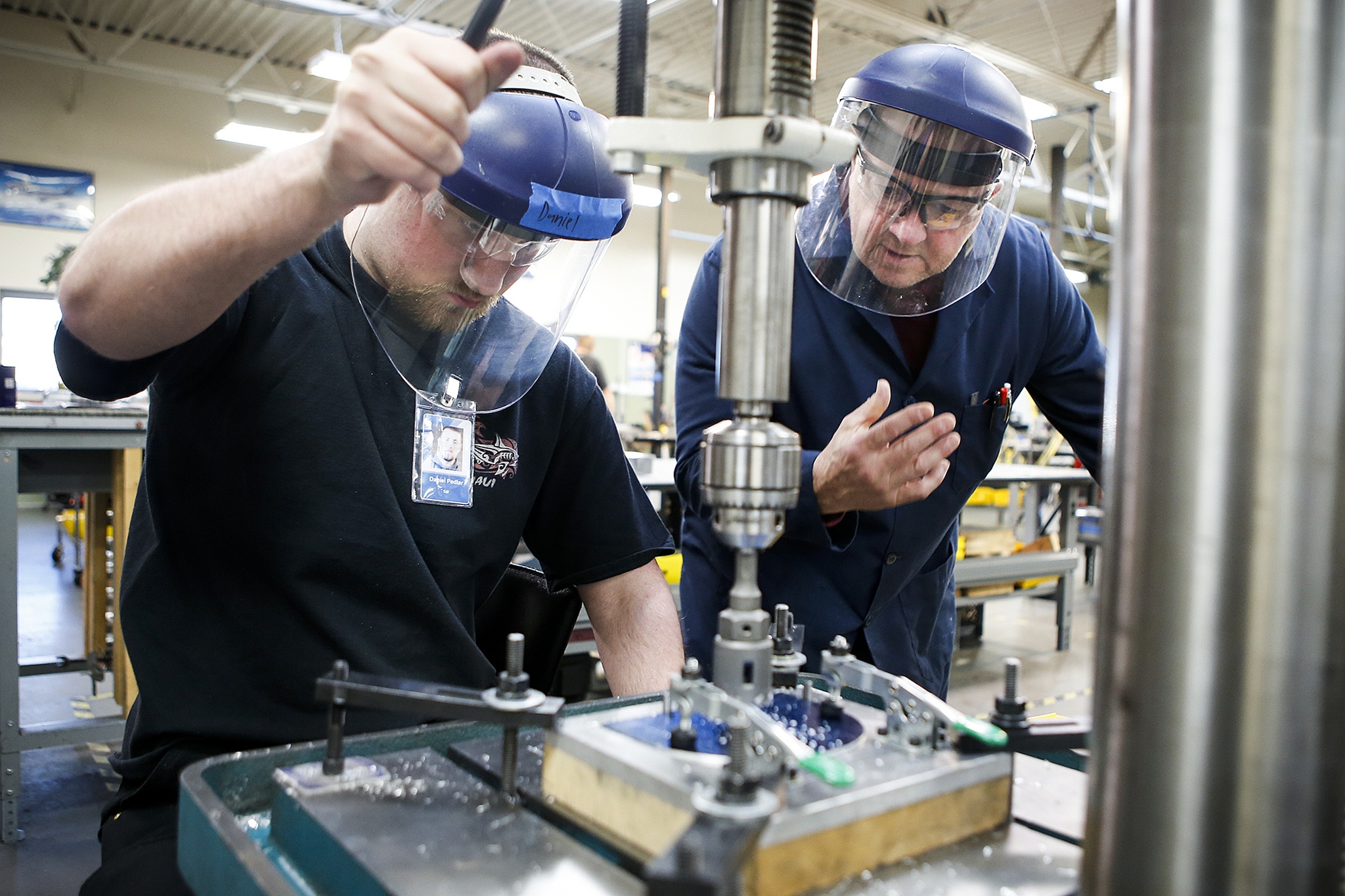 Instructor Rick Smith (right) helps student Daniel Pedlar with a drill press at the Washington Aerospace Training & Research Center at Paine Field in Everett on Dec. 16. (Ian Terry / The Herald)