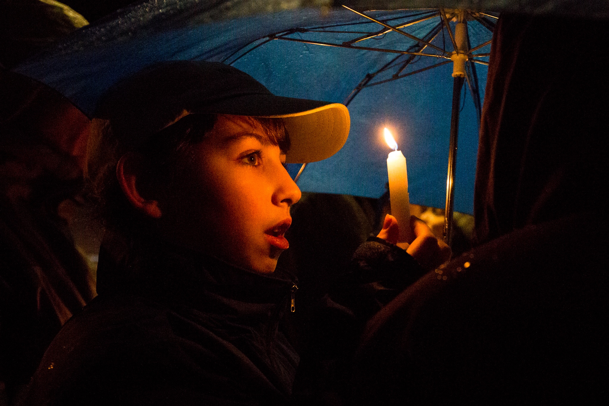 Ryder Ransom, 11, holds up his candle while singing Hanukkah songs during the fifth annual public menorah lighting ceremony at the Lynnwood City Hall on Monday. About 100 people gathered to sing, eat and celebrate the third night of Hanukkah. (Daniella Beccaria / The Herald)