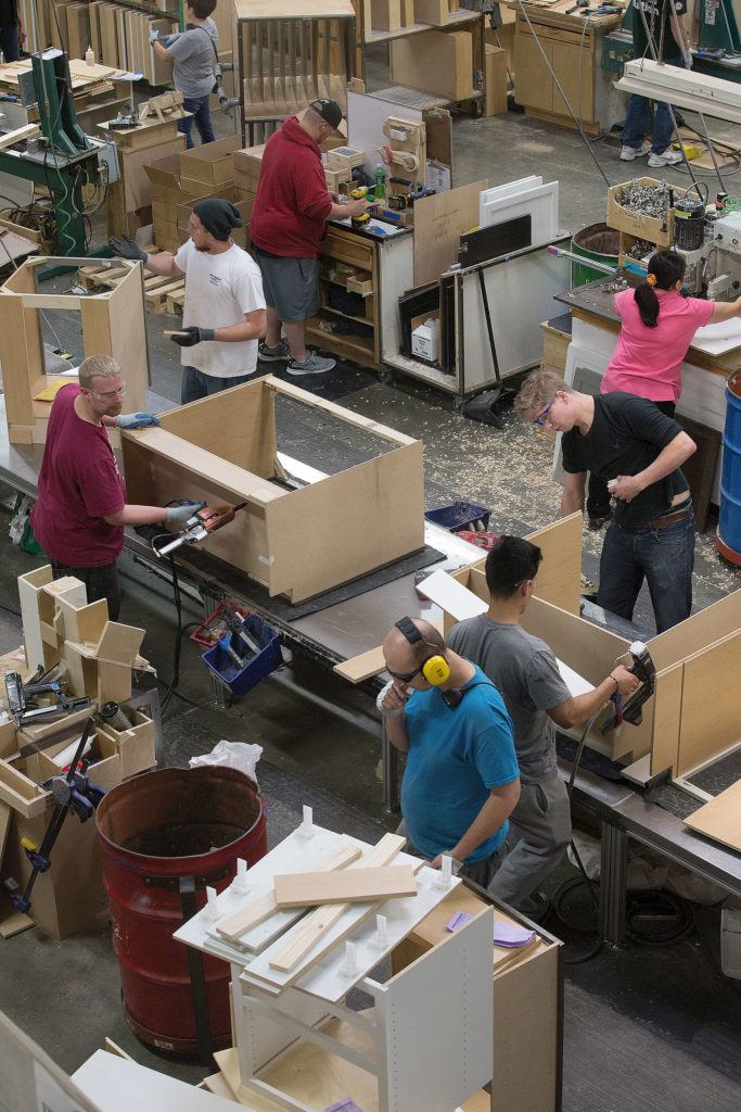 Workers assemble custom cabinets at Canyon Creek Cabinets in Monroe. At its 2007 peak, sales were $92 million with a workforce of 715. Under Bill Weaver’s leadership, Canyon Creek successfully survived the recession and downturn in sales. They are surging forward with 2016 projected sales at $60 million and a workforce of 440 employees. (Andy Bronson / The Herald)
