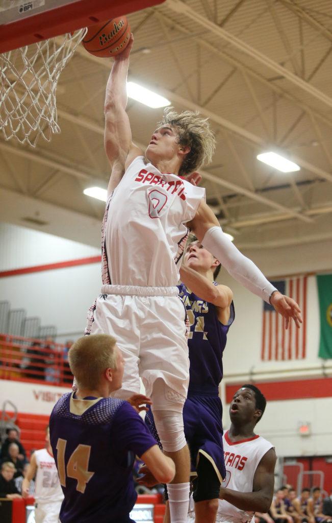 Stanwood’s A.J. Martinka goes up for a dunk but is called for a charging foul with Lake Stevens’ Noah Wallace (14) and Wyatt Wahlberg (24) defending during a game Tuesday in Stanwood. (Andy Bronson / The Herald)
