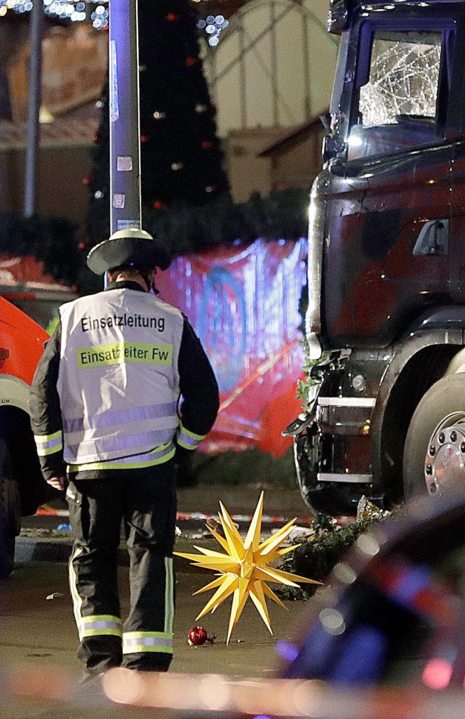 A firefighter walks past a star after a truck ran into crowded Christmas market in Berlin, Germany, on Monday, Dec. 19, killing several people. (AP Photo/Michael Sohn)
