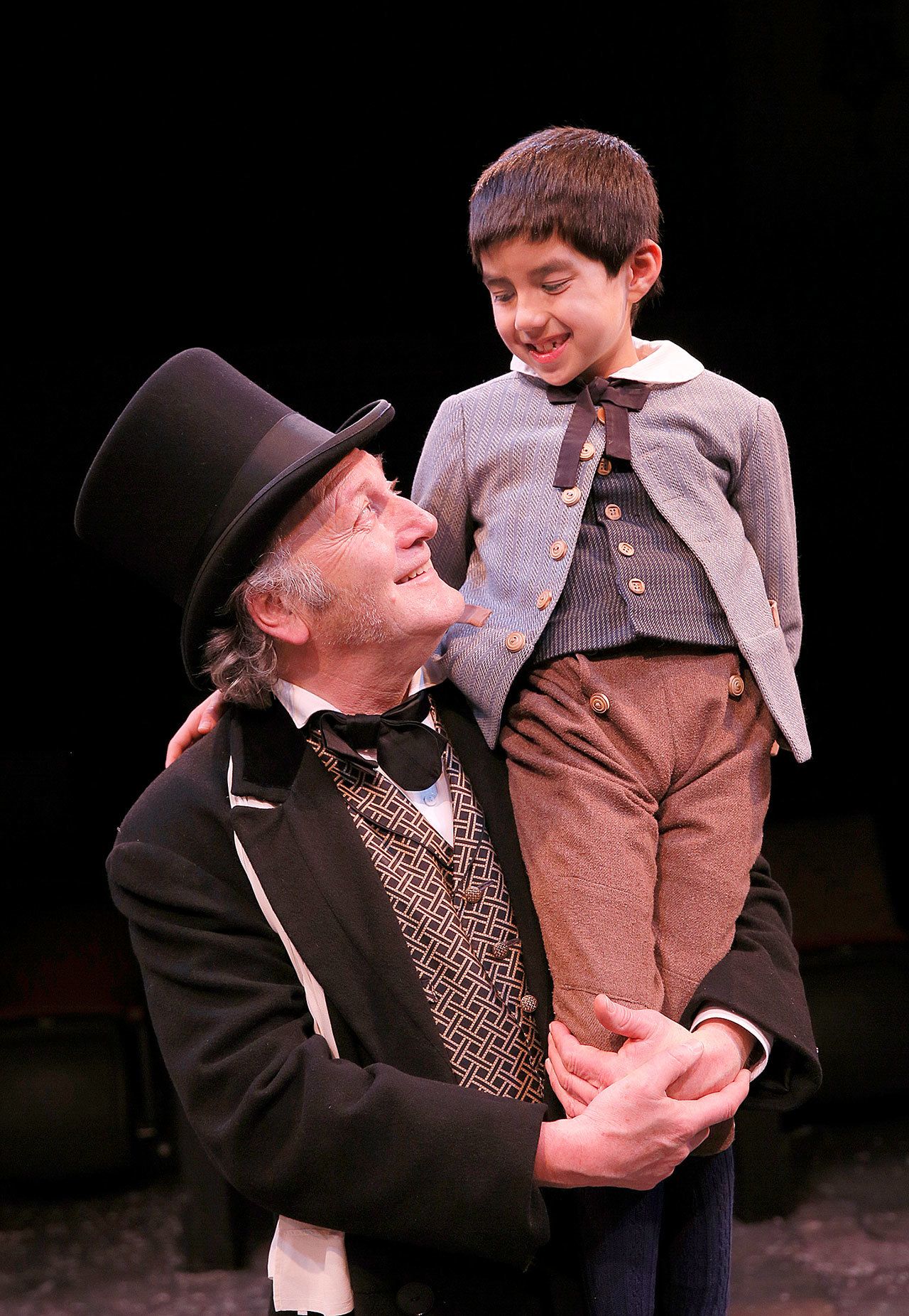 Frank Corrado (Ebenezer Scrooge) and Keagan Estes (Tiny Tim) star in ACT Theatre’s “A Christmas Carol,” playing through Dec. 28 in Seattle. (Chris Bennion photo)