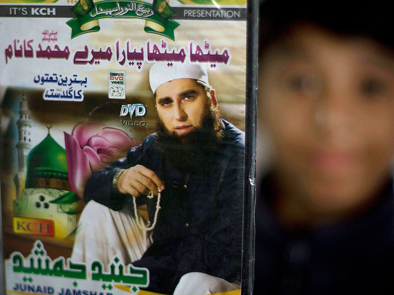In this Dec. 3, 2014 photo, a vendor shows a DVD of Pakistan’s Junaid Jamshed at a stall in Islamabad, Pakistan. (AP Photo/B.K. Bangash, File).