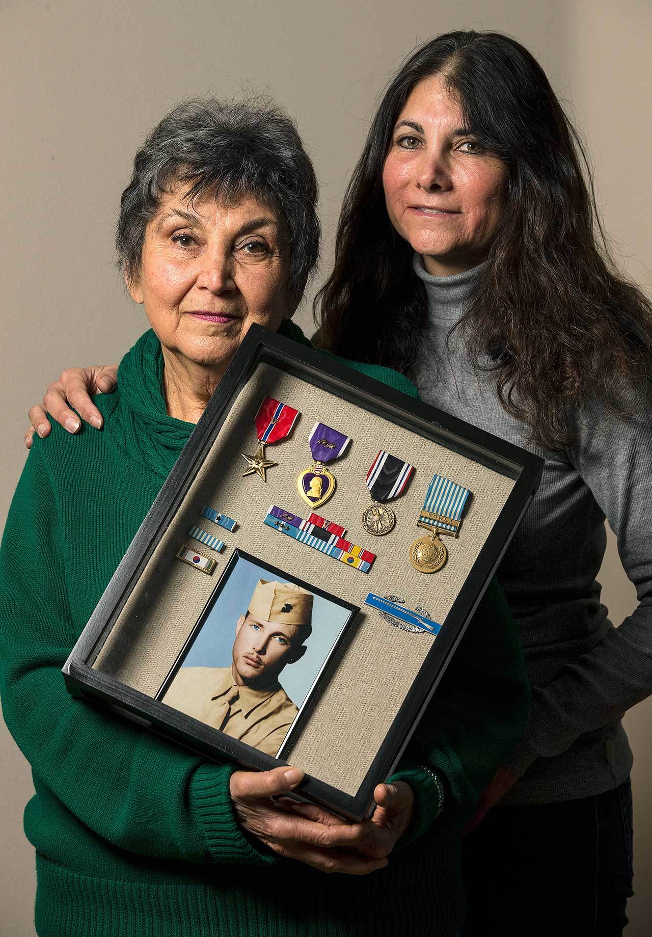 With her daughter Valerie Rocha, Shirley Nordin holds a shadowbox containing medals and a photo of her brother-in-law and Korean War Army Cpl. David T. Nordin, Jr., whose remains were recently identified, at her home on Thursday, Dec. 15, in Lynnwood. Nordin and her daughter will attend a funeral for her brother-in-law on Friday. (Andy Bronson / The Herald)