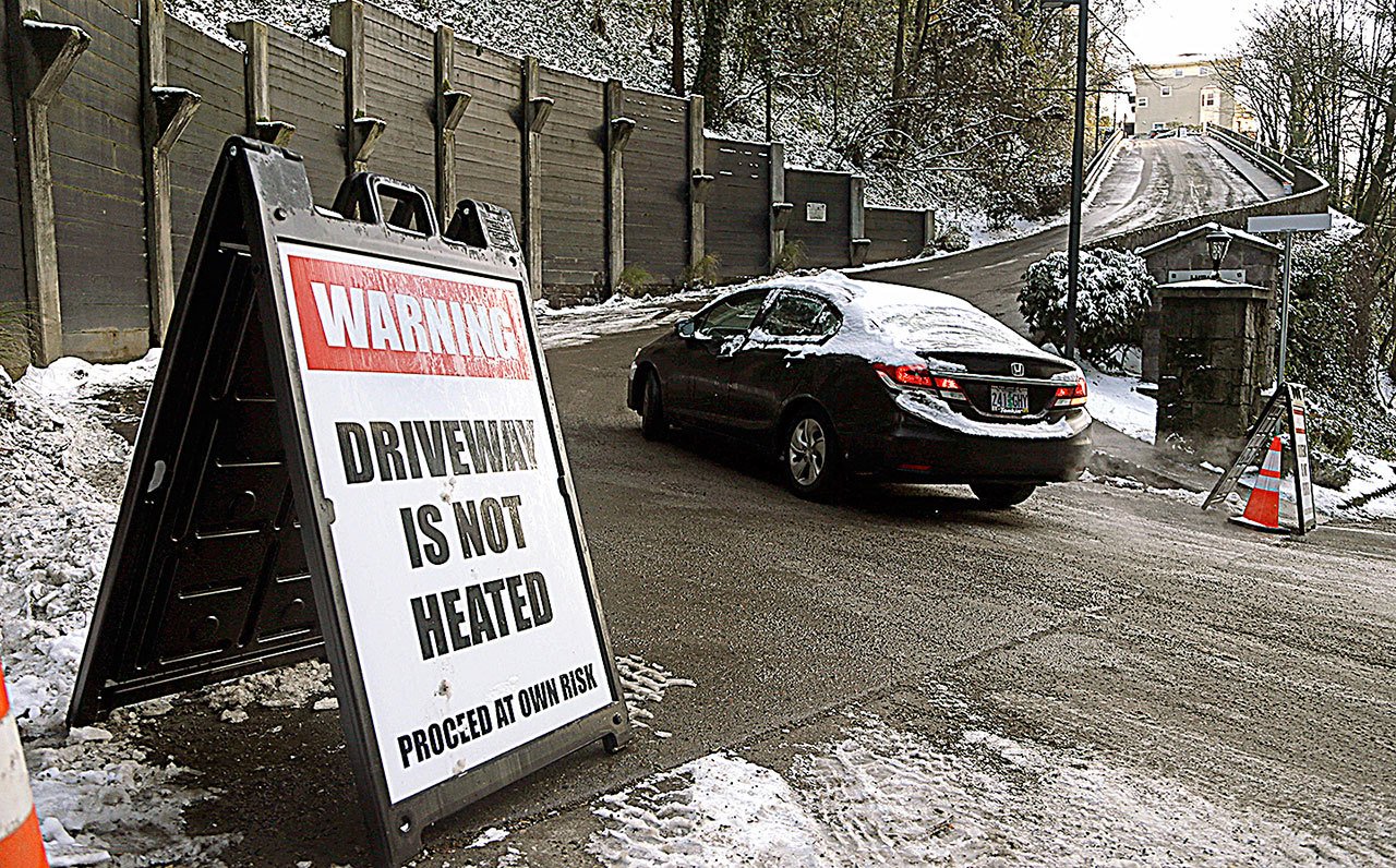A car attempts to head up a slippery road in Portland, Oregon, on Friday, Dec. 16. Schools across the Portland metro area closed and driving was slow for another day as below-freezing temperatures prevent ice and snow from Wednesday’s snow storm from melting. (AP Photo/Don Ryan)