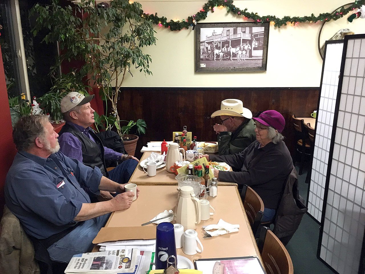 Grant County Public Forest Commission members chat before their meeting at the Squeeze-In Restaurant & Deck in John Day, Oregon, on Dec. 7. The commission was created by voters in 2002 and was dissolved by a judge recently. Its members still keep meeting, though, to find a way forward amid a struggle for control over federal lands in the West. From left are Dave Traylor, Jim Sproul, Mike Smith and Elaine Smith. (AP Photo/Andrew Selsky)