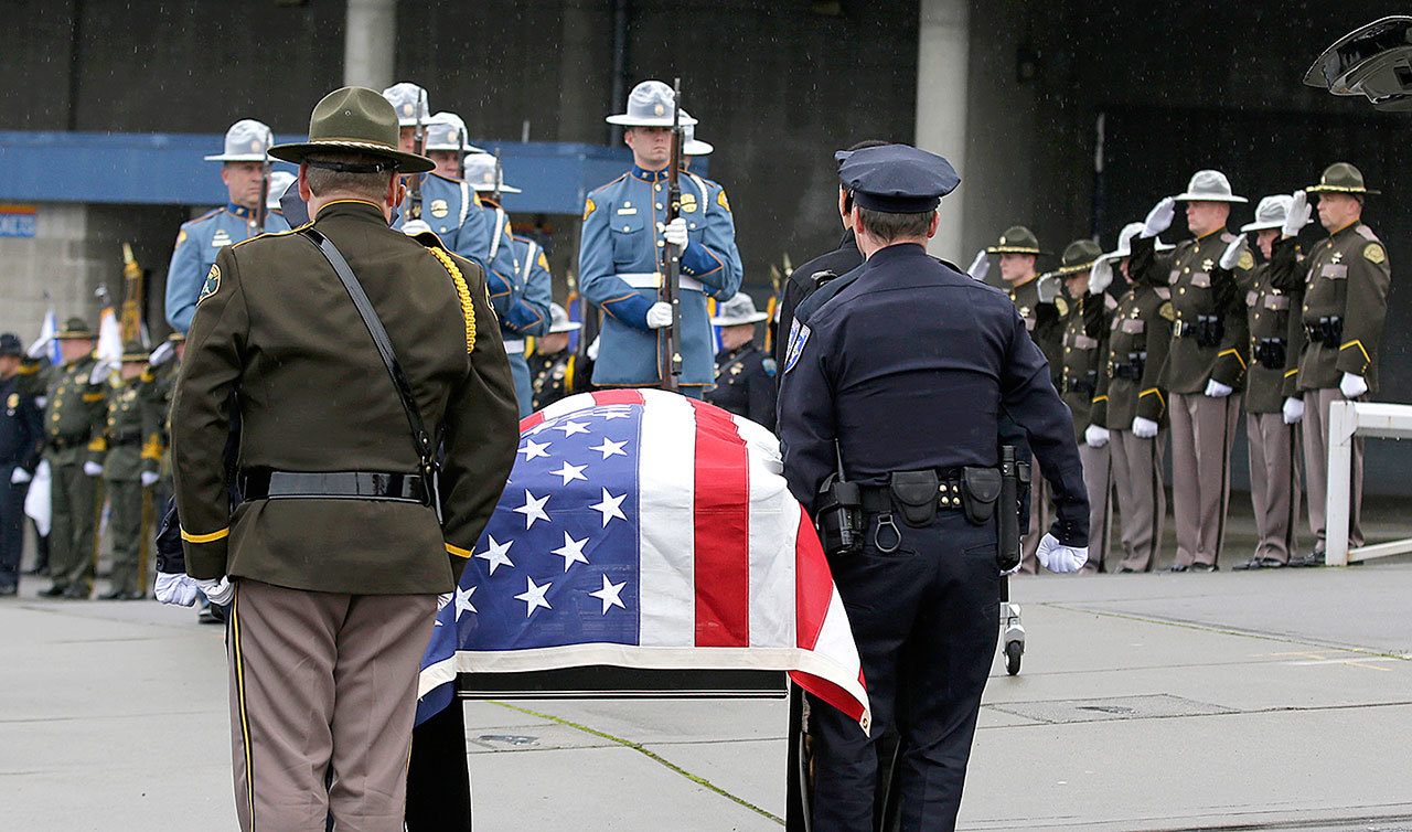 The flag-draped casket bearing the body of Tacoma Police Officer Reginald “Jake” Gutierrez is carried outside the Tacoma Dome on Friday, Dec. 9, before a public memorial service in Tacoma. Gutierrez was fatally shot Nov. 30 while responding to a domestic dispute. (AP Photo/Ted S. Warren)