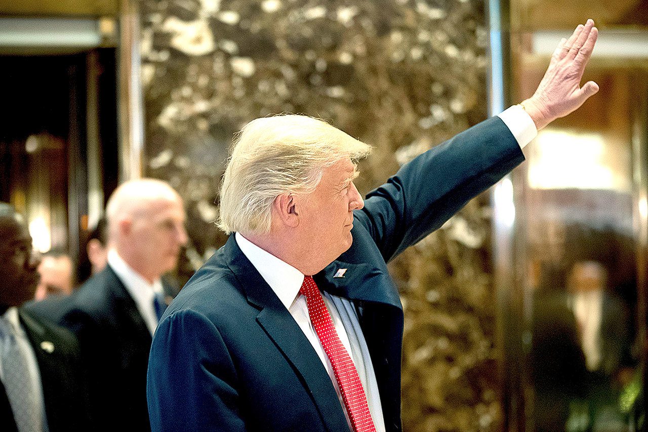 President-elect Donald Trump waves to visitors in the lobby of Trump Tower in New York on Tuesday, Dec. 6. (AP Photo/Andrew Harnik)