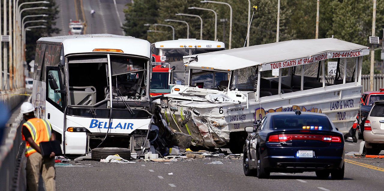 In this Sept. 24, 2015, photo, a “Ride the Ducks” amphibious tour bus (right) and a charter bus remain at the scene of a fatal collision on the Aurora Bridge in Seattle. Ride the Ducks International has agreed to pay up to $1 million in civil penalties under a consent order reached with federal transportation officials. (AP Photo/Elaine Thompson, File)