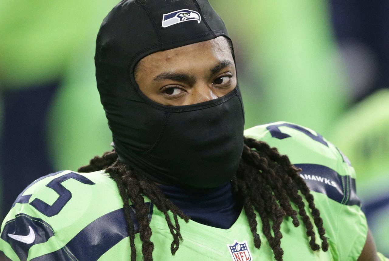 Seahawks cornerback Richard Sherman wears a mask to stay warm as he stretches before a game against the Rams on Dec. 15 in Seattle. (AP Photo/Scott Eklund)