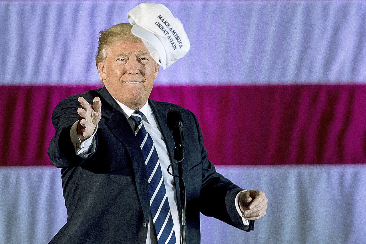 President-elect Donald Trump throws a hat into the audience while speaking at a rally in a DOW Chemical Hanger at Baton Rouge Metropolitan Airport on Friday, Dec. 9, in Baton Rouge, Louisiana. (AP Photo/Andrew Harnik)