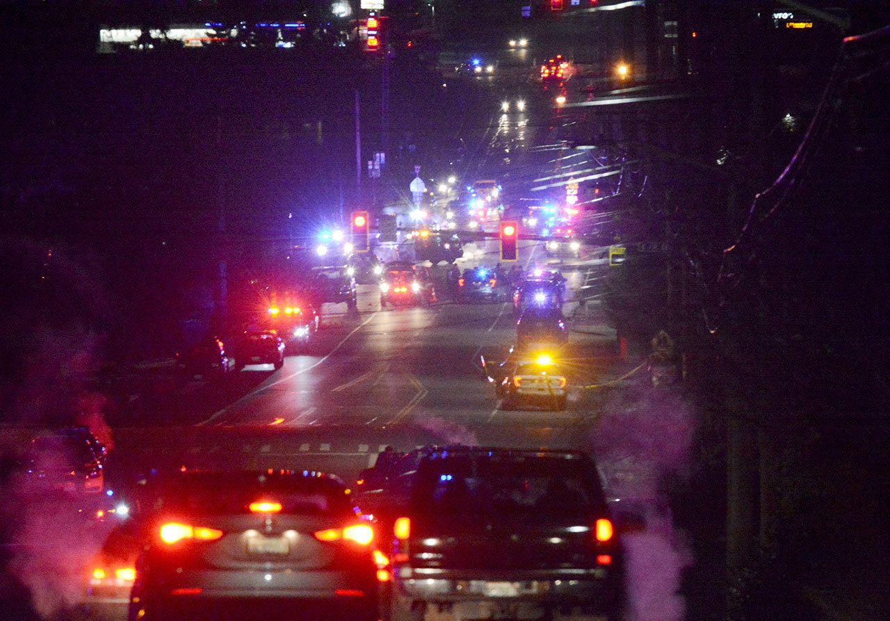 Law enforcement vehicles gather near Skagit Valley College in Mount Vernon on Thursday. A Mount Vernon Police officer was shot and critically wounded by a suspect who was then barricaded in a Mount Vernon residence before being taken into custody overnight, authorities said. (Brandy Shreve/Skagit Valley Herald via AP)