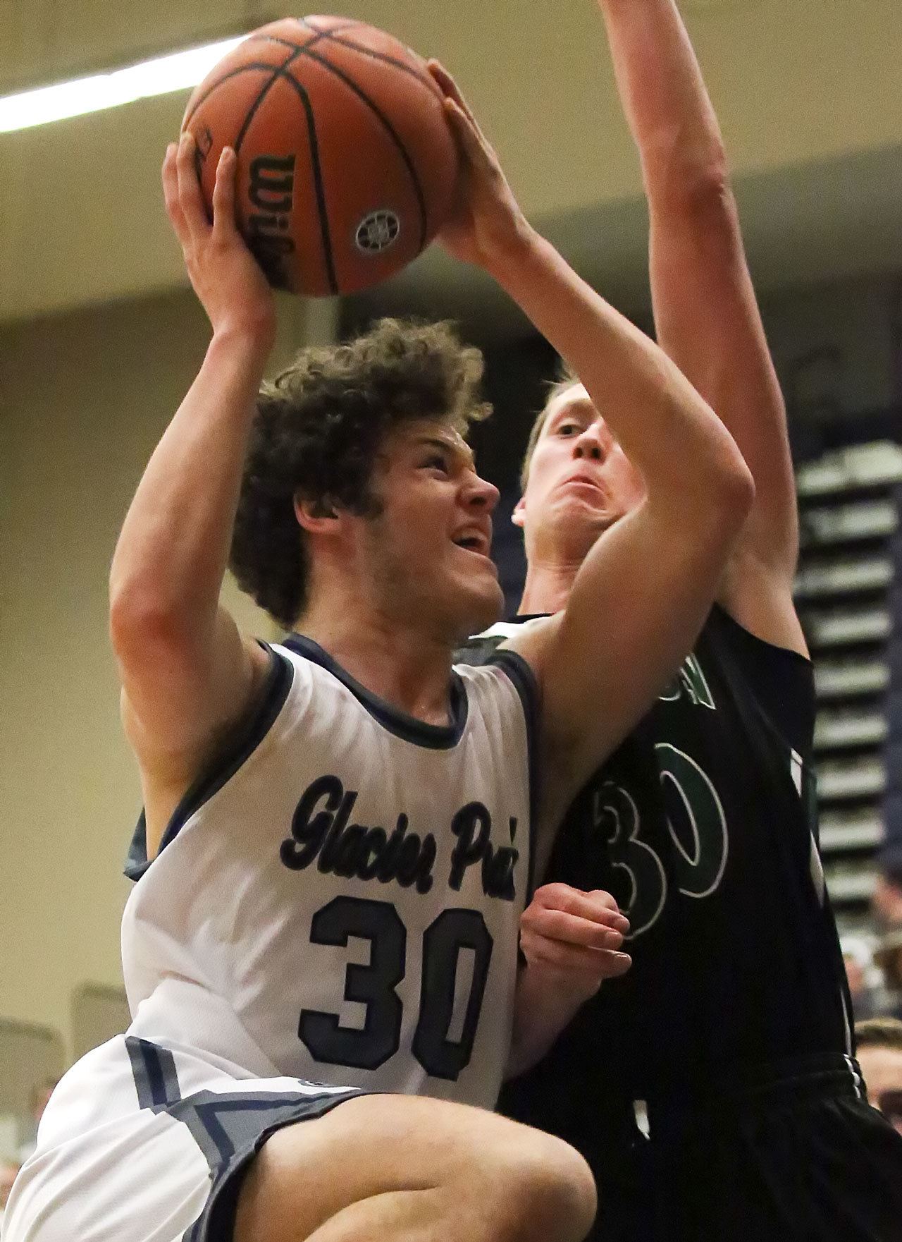 Glacier Peak’s Bobby Martin (left) attempts a shot with Jackson’s Hunter Johnson defending during a game Friday at Glacier Peak High School in Snohomish. The Grizzles defeated the Timberwolves 64-41. (Kevin Clark / The Herald)