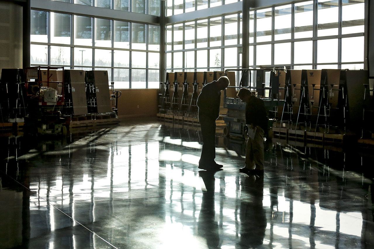 School officials look over the flooring finish done by the district during Wednesday morning’s dedication of the Food Commons at Marysville Pilchuck High School. (Kevin Clark / The Herald)