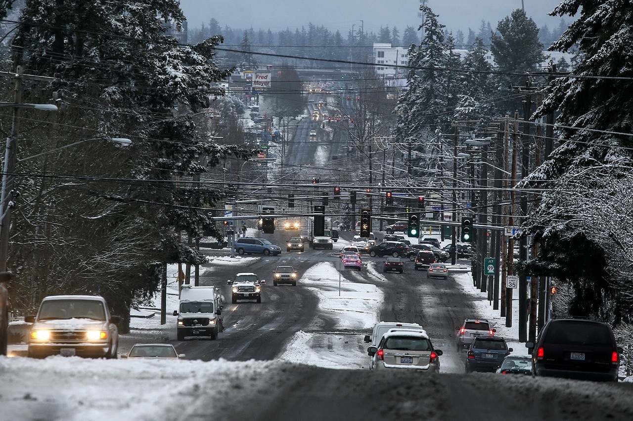 Snow and slush covers 196th Street Southwest in Lynnwood as traffic moves along the morning of Dec. 9. (Ian Terry / The Herald)