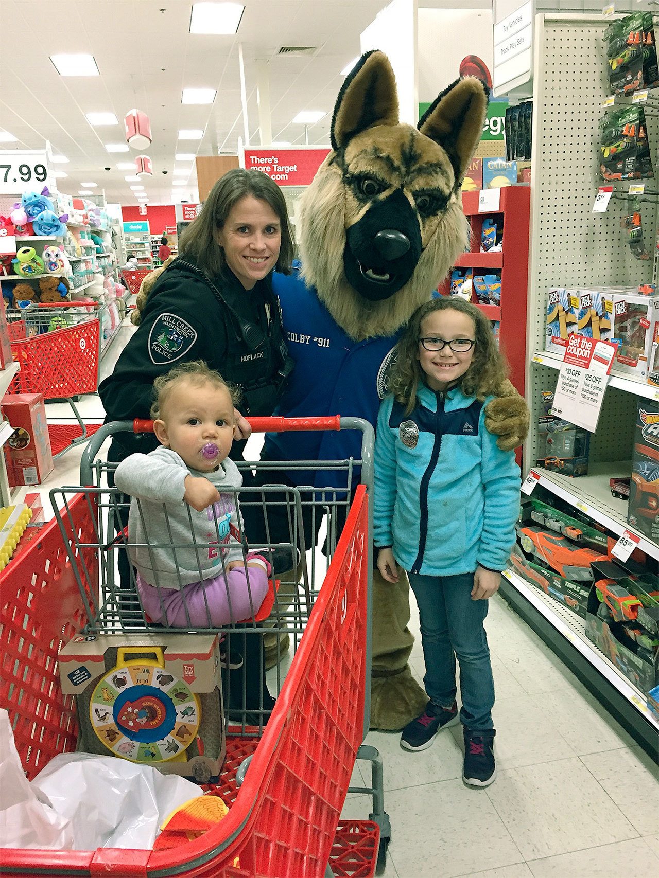 Mill Creek Police Det. Tara Hoflack and Colby the Crime Prevention Dog help kids shop for Christmas as part of an annual Heroes and Helpers event. (Contributed photo)