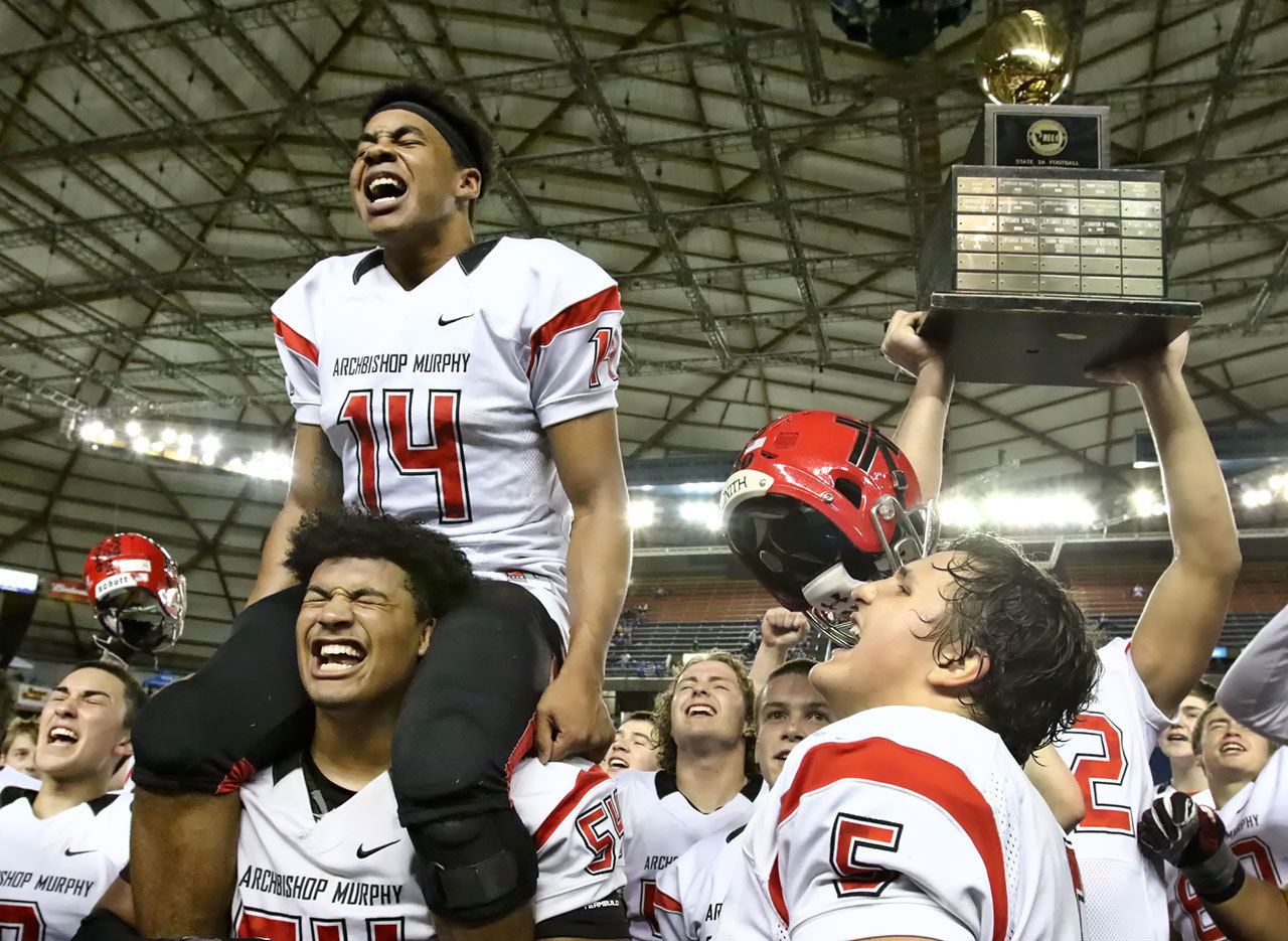 Archbishop Murphy’s Anfernee Gurley (14) sits atop Jackson Yost’s shoulders as teammates celebrate after the Wildcats beat Liberty 56-14 in the Class 2A state championship game Saturday afternoon at the Tacoma Dome. (Kevin Clark / The Herald)