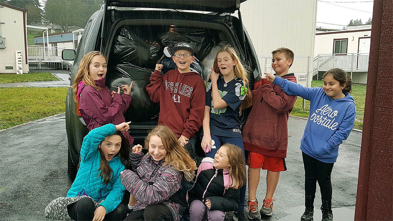 Seattle Hill Elementary School students show a car trunk stuffed with over 700 stuffed toys, bound for Christmas House. The school took first place in an Everett Elks Lodge 479 contest to see which school could donate the most stuffed toys. They received a trophy for their efforts. (Contributed photo)