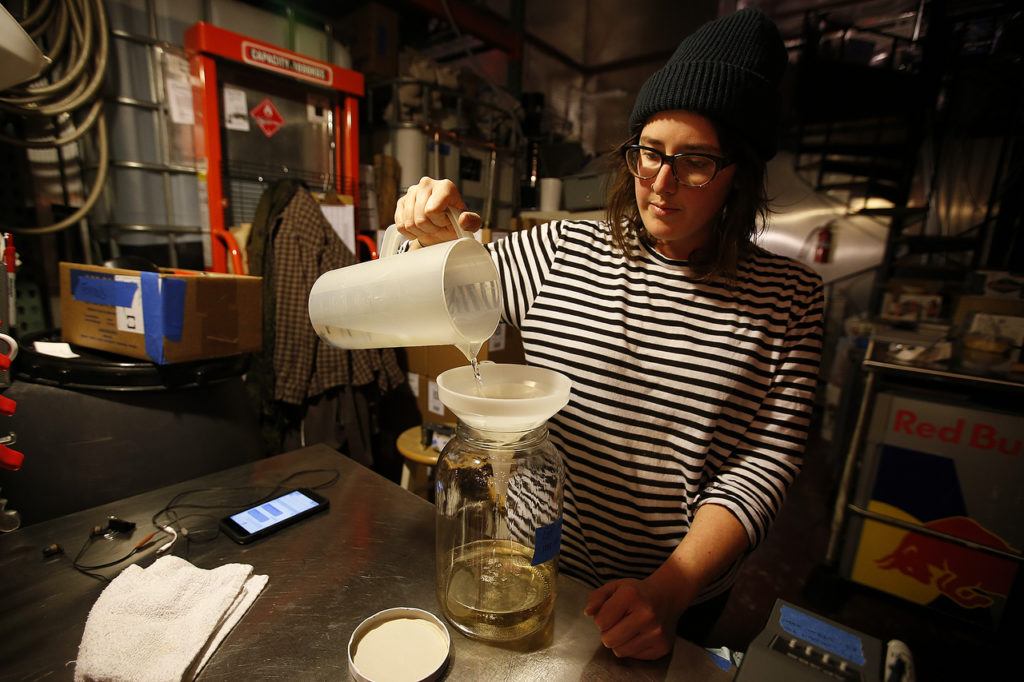 Old Ballard Liquor Co.’s Jane Frazee pours vodka through an infuser filled with cloves at the distillery, located just a few blocks east of the Ballard bridge’s north side, on Thursday, Dec. 8. (Ian Terry / The Herald)
