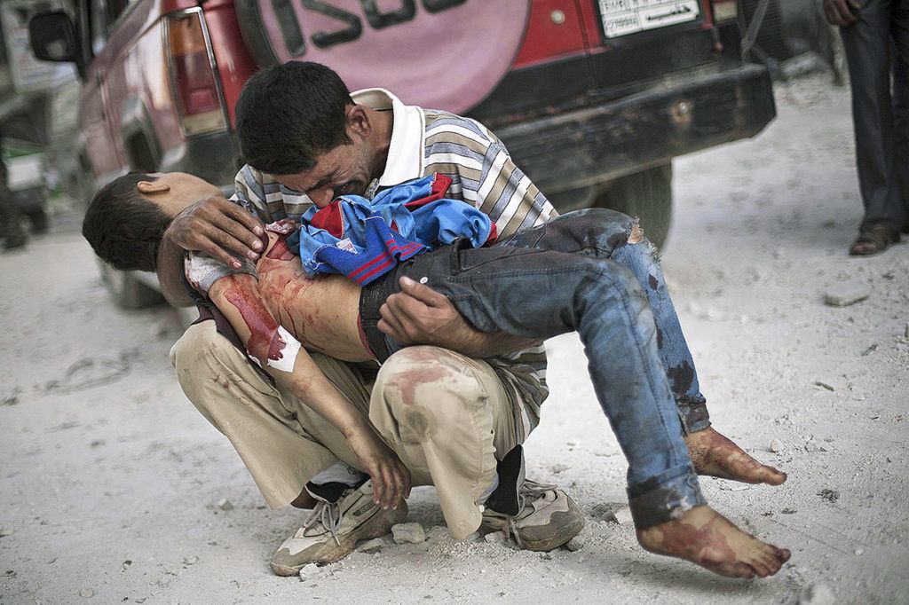 A man cries while holding the body of his son, killed by the Syrian Army, near Dar El Shifa hospital in Aleppo, Syria, on Oct. 3, 2012. (AP Photo/Manu Brabo, File)

