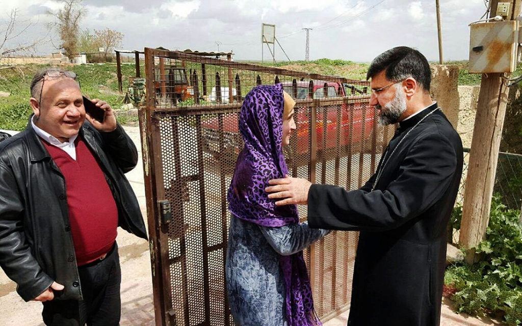 Assyrian Christian bishop Mar Afram Athneil (right) greets Maryam David Thalya after her release from more than a year of captivity by the Islamic State group in this March 27, 2016, photo from the northeastern Syrian city of Hassakeh. Thalya was the last to be freed from 226 Assyrians captured by the militants when they overran Assyrian Christian villages in northern Syria. Working secretly, Athneil negotiated with the militants as the Assyrian diaspora worldwide donated money for ransoms. In the end, millions of dollars ended up in IS pockets, but the hostages were freed. (Assyrian Church of the East Relief Organization via AP video)
