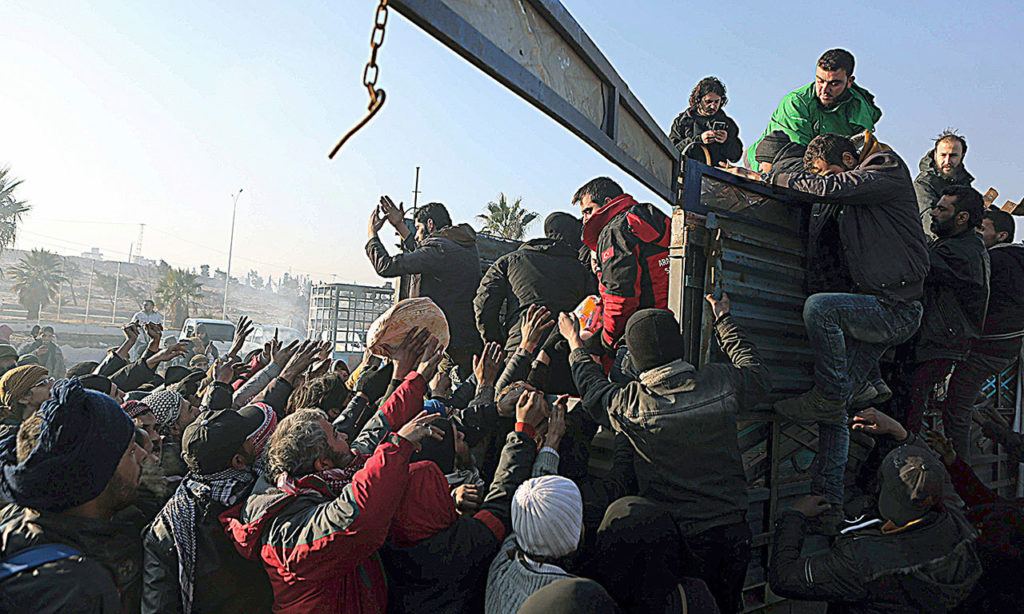 Syrians evacuated from the embattled Syrian city of Aleppo during the ceasefire get free bread after their arrival at a refugee camp in Rashidin, near Idlib, Syria, early Monday, Dec. 19. (AP Photo)
