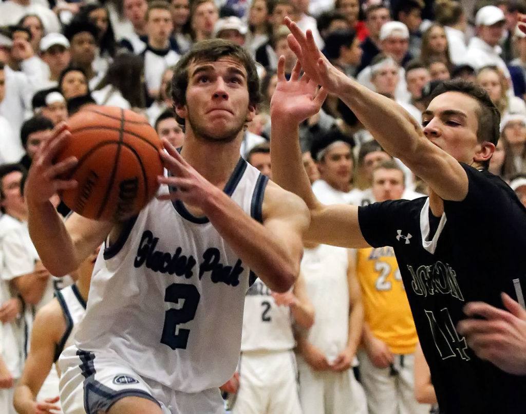 Glacier Peak’s Austin Petz drives the baseline with Jackson’s Paul Doney defending during a game Friday at Glacier Peak High School in Snohomish. The Grizzles defeated the Timberwolves 64-41. (Kevin Clark / The Herald)
