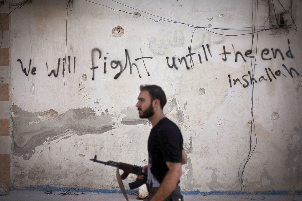 A Free Syrian Army soldier walks through a street in Amariya district in Aleppo, Syria, on Sept. 10, 2012. (AP Photo/Manu Brabo, File)

