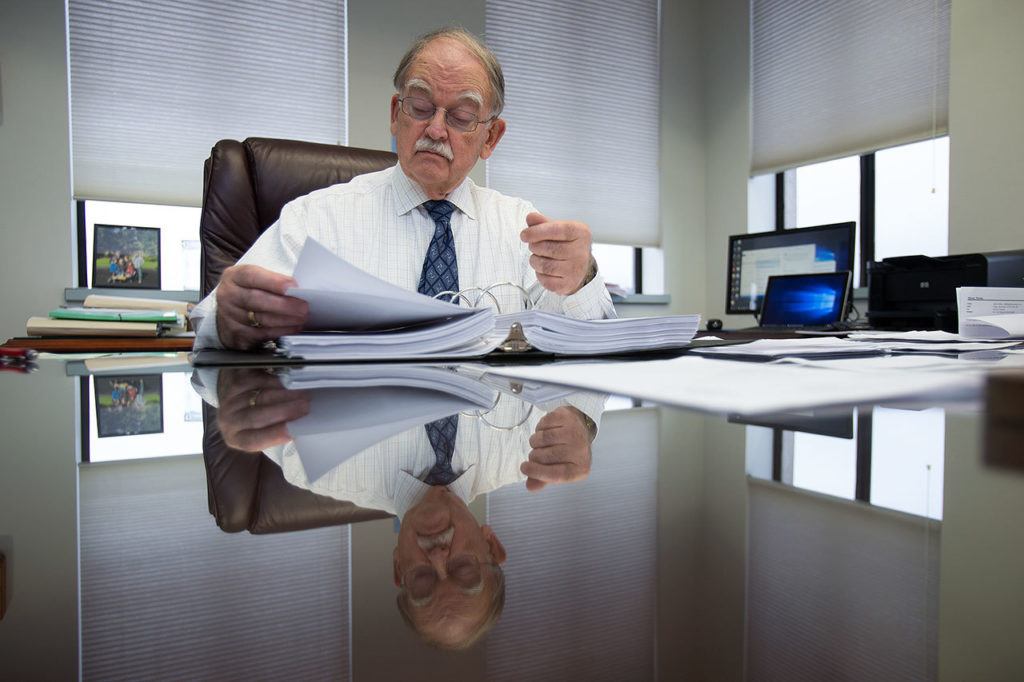 Wynne reviews documents on the data dissemination dolicy for the state court’s data dissemination committee, for which he serves as chairman. (Andy Bronson / The Herald)
