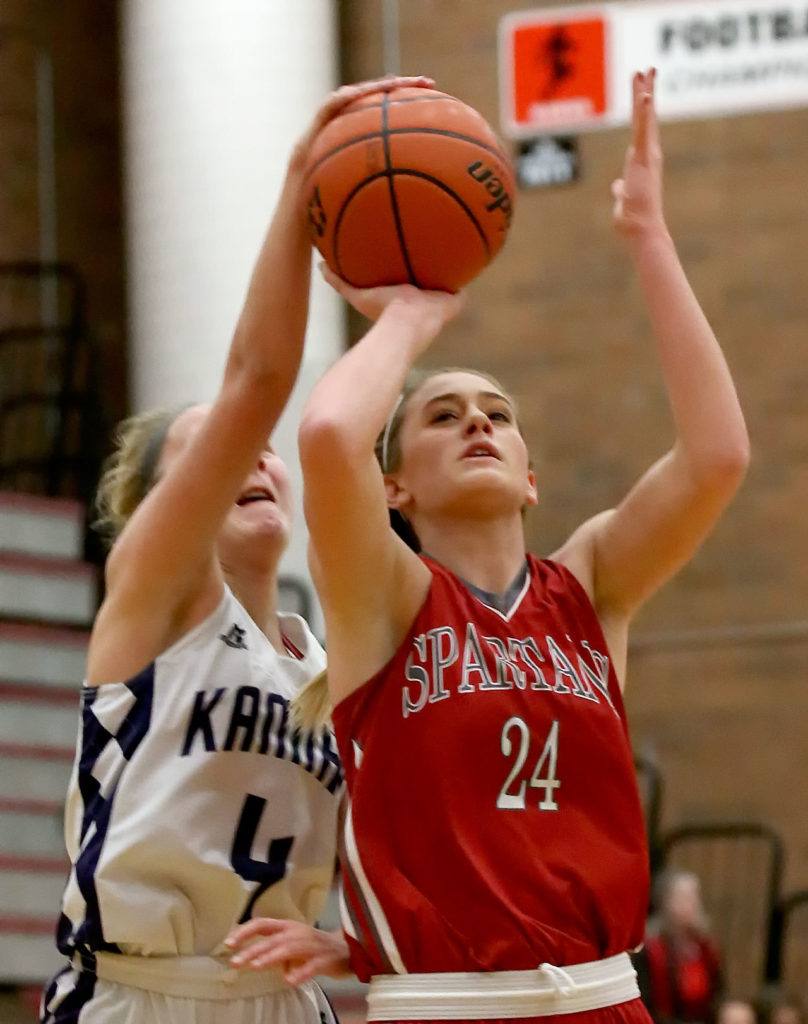 Kamiak’s Alexie Morris blocks and fouls Stanwood’s Jillian Heichel’s shot attempt during the Mountlake Terrace Holiday Tournament Friday night at Mountlake Terrace High School. (Kevin Clark / The Herald)
