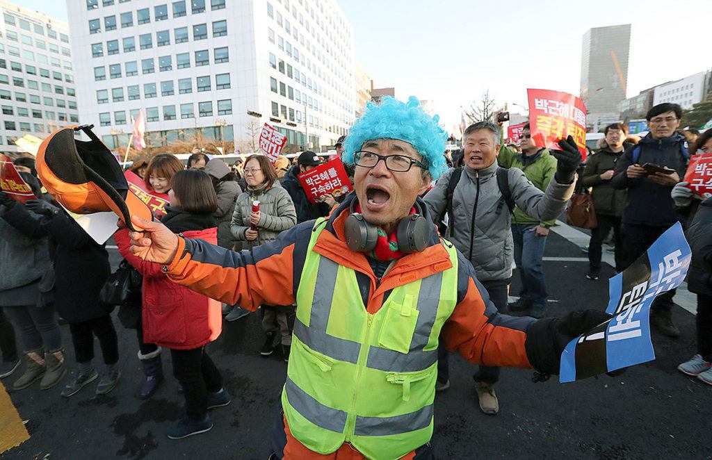 A protester dances after hearing the President Park Geun-hye’s impeachment in front of the National Assembly in Seoul, South Korea, on Friday, Dec. 9. (AP Photo/Lee Jin-man)
