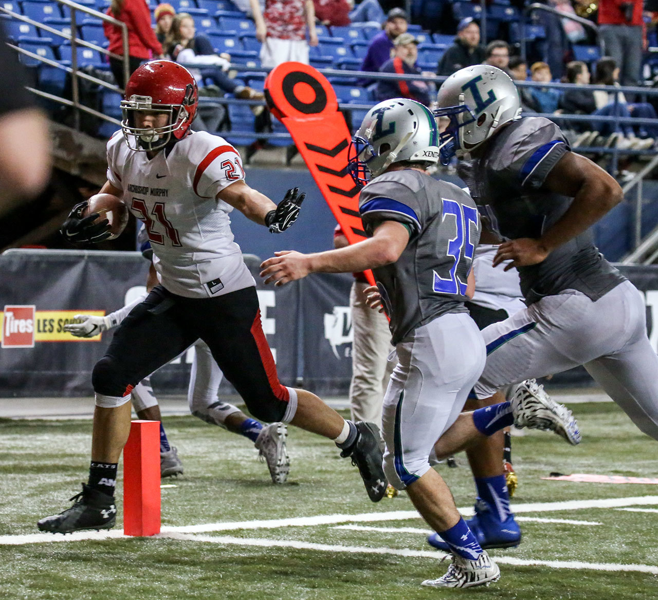 Archbishop Murphy’s Collin Montez crosses the goal line for a touchdown with Liberty’s Juan Flores (35) and Julian Bruce trailing during the 2A state championship game on Saturday at the Tacoma Dome. Archbishop Murphy defeated Liberty 56-14. (Kevin Clark / The Herald)
