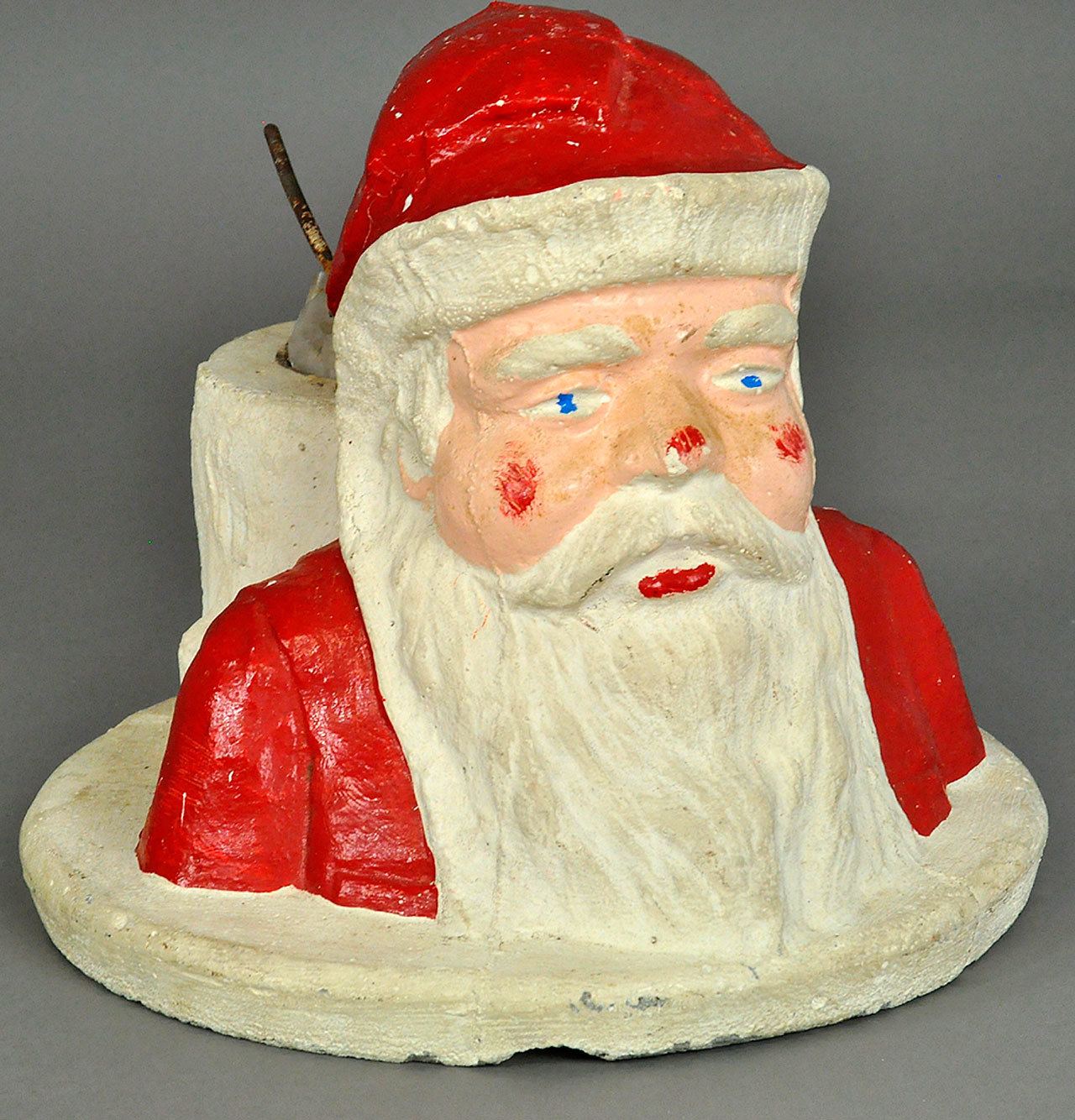 This rather serious Santa is a Christmas tree stand made of concrete. It sold last year for $118, less than expected. The heavy stand was made fora feather tree not a natural tree that needed water. (Cowles Syndicate Inc.)