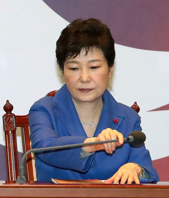 South Korean President Park Geun-hye adjusts a microphone during an emergency Cabinet meeting at the presidential office in Seoul, South Korea, on Friday, Dec. 9. (Baek Sung-ryul/Yonhap via AP)