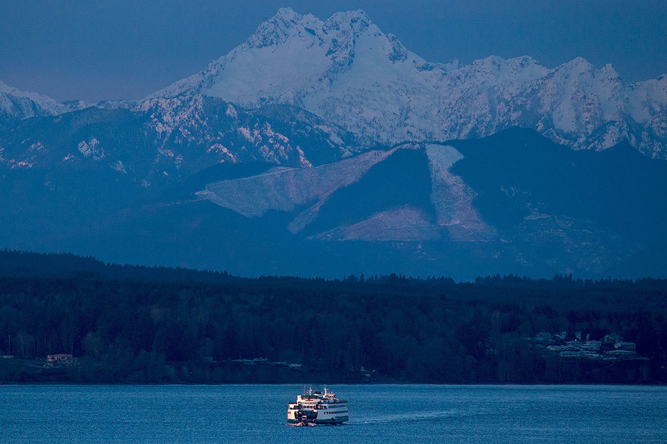 Ian Terry / The Herald A Washington State Ferry heads from Kingston to Edmonds early Thursday morning as the Olympic Mountains loom in the distance. Lowland snow with a possible accumulation of 1-3 inches is expected Thursday evening. Photo taken on 12082016