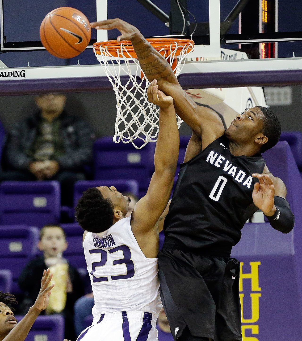 Nevada’s Cameron Oliver (0) blocks a shot by Washington’s Carlos Johnson in the first half of Sunday’s game in Seattle. (AP Photo/Elaine Thompson)