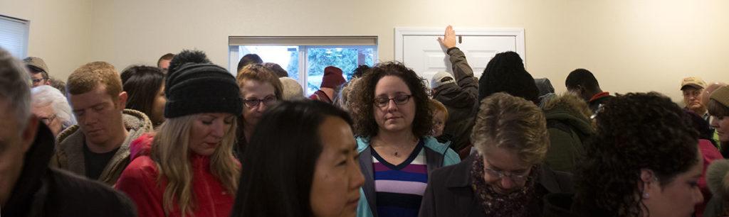 A guest blesses the front door as Ray and Sandy Flores accept the keys to their new home from Habitat for Humanity of Snohomish County on Saturday in Everett. (Andy Bronson / The Herald)
